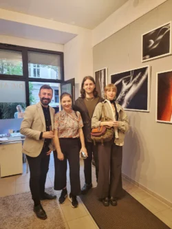 Vier Galeriebesucher posierten unter gerahmten Abzügen in warmem Licht vor Ort, polierte Personal Branding Fotografie in Berlin.