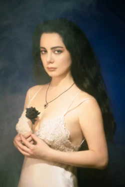 Siyah bir gül tutan dantel slipli bir kadının karamsar sinematik stüdyo portresi, Avrupa'daki projeler için cilalı editoryal çekim