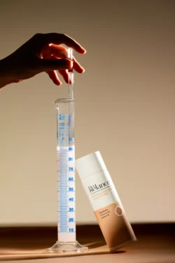 Pipetli ve cam dereceli silindirli bir saç kremi şişesinin cilalı stüdyo çekimi - Avrupa'daki projeler için güzellik ürünü fotoğrafçılığı.