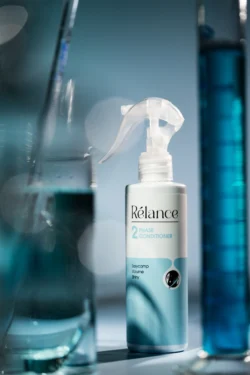 Relance 2 fazlı saç kremi sprey şişesinin soğuk mavi stüdyo ışığında cilalı ürün fotoğrafçılığı, Avrupa çapında güzellik ürünleri çalışması.