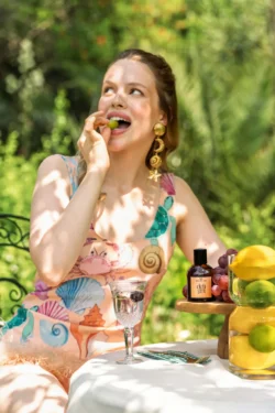 Cesur stil ve ürün aksesuarlarıyla üzüm tadımı yapan bir modelin güneşli sinematik editoryal çekim portresi - Avrupa'da fotoğrafçı