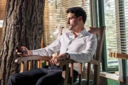 Beyaz gömlekli bir adamın güneşli panjurların altında elinde bakım şişesi tutan sinematik portresi; Avrupa'daki projeler için reklam ürünü fotoğrafçılığı.