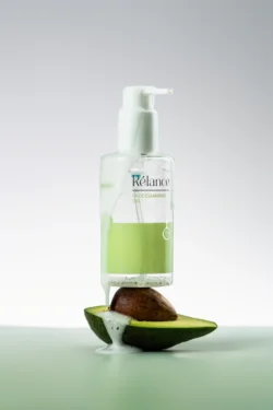 İkiye bölünmüş bir avokadonun üzerine köpük damlatan bir yüz temizleme jeli şişesinin cilalı stüdyo ürün fotoğrafçılığı; Avrupa'daki projeler için fotoğrafçı.