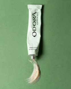 Yeşil fonda sıkılmış bir tüp saç boyası kreminin cilalı ürün fotoğrafçılığı, stüdyo çekimi, Avrupa'daki projeler için fotoğrafçı.