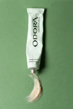 Avrupa'daki projeler için bir fotoğrafçı tarafından stüdyoda çekilmiş, yeşil fon üzerinde sıkılmış saç boyası tüpünün cilalı ürün fotoğrafı.