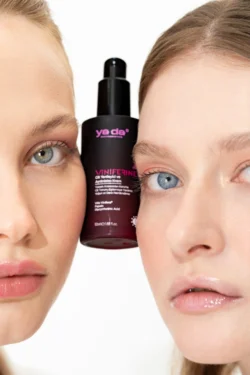 Viniferine serum şişesini çevreleyen iki modelin yakın plan güzellik çekimi, Avrupa'daki projeler için cilalı stüdyo güzellik ve ürün fotoğrafçılığı.