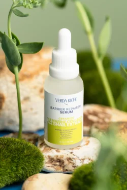 Yumuşak doğal ışıkla taşlar ve yosunlar üzerinde yeşil etiketli bir serum damlalığının cilalı ürün fotoğrafçılığı; Avrupa için fotoğrafçı.