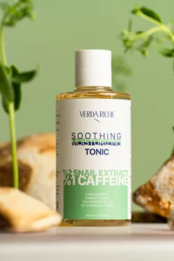 Verda Riche yatıştırıcı tonik şişesinin yumuşak yeşil bokeh ve doğal aksesuarlarla cilalanmış ürün fotoğrafı - Avrupa genelinde ürün fotoğrafçılığı.