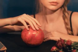 Sinematik editoryal çekim: çatlamış bir nara dokunan örgülü bir modelin yumuşak ışıklı portresi, Avrupa'daki projeler için cilalı görüntüler.