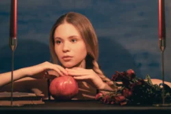 Nar, mumlar ve kurutulmuş güllerle genç bir kadının sinematik stüdyo portresi - Avrupa'da bir fotoğrafçı tarafından yapılan editoryal çekim.