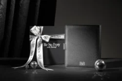 Siyah deri folyo ve saten kurdeleli markalı hediye kutusunun stüdyo ürün fotoğrafçılığı; cilalı, yüksek etkili, Avrupa.