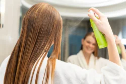 Aynayla aydınlatılmış bir banyoda saç ürününü buğulayan bir kadının cilalı güzellik ve ürün fotoğrafçılığı, Avrupa'daki projeler için fotoğrafçı.