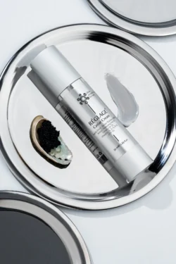 Réglage Havyar Kremi'nin havyar ve krema bulaşmış yansıtıcı bir tepsi üzerinde cilalı stüdyo ürün fotoğrafı; Avrupa için fotoğrafçı.