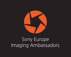 Orange Sony Europe Imaging Ambassadors shutter logo on dark background, indicating Burak Bulut Yildirim's expert artist portrait work in Berlin.